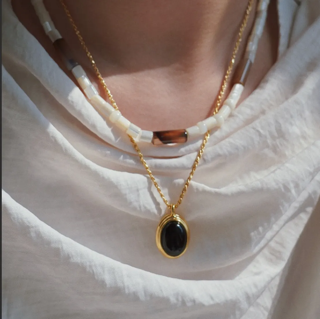 Screenshot_2024-10-27_at_6.47.20_AM Non-Fading Titanium Steel Cat's Eye Stone Necklace – Vintage Black Gold French Style Luxury Sweater Chain - Image 1