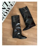 Pair of black pointed-toe knee-high boots with buckle detail