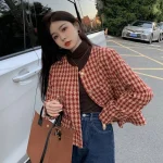 Model wearing a red and cream houndstooth cropped round-neck jacket